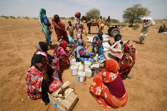 Sudanese refugees, who have fled the violence in their country, sit after they received the food rations from World Food Program