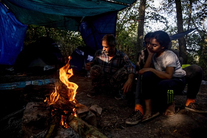 Iraqi migrants sit near a fire waiting to cross into Britain at a makeshift migrants camp in Dunkirk, northern France. (File/AFP