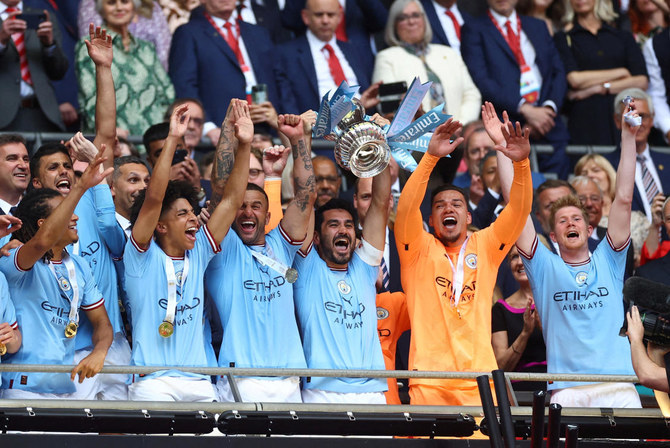 Manchester City’s Ilkay Gundogan lifts the trophy as he celebrates with his teammates after winning the FA Cup. (Reuters)