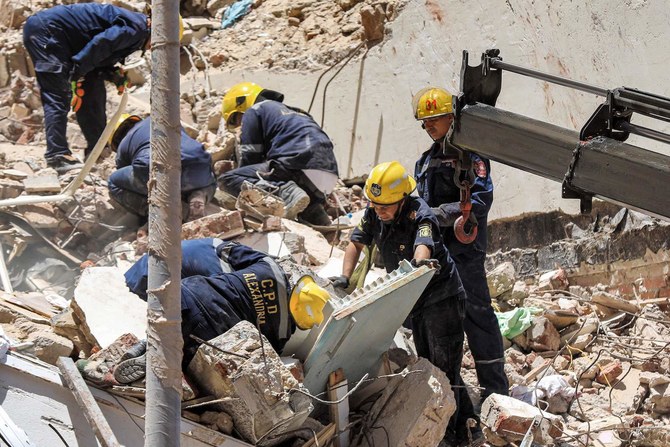 Civil defense first responders search through rubble at the scene of a collapsed 13-storey-building in the Sidi Bishr district.