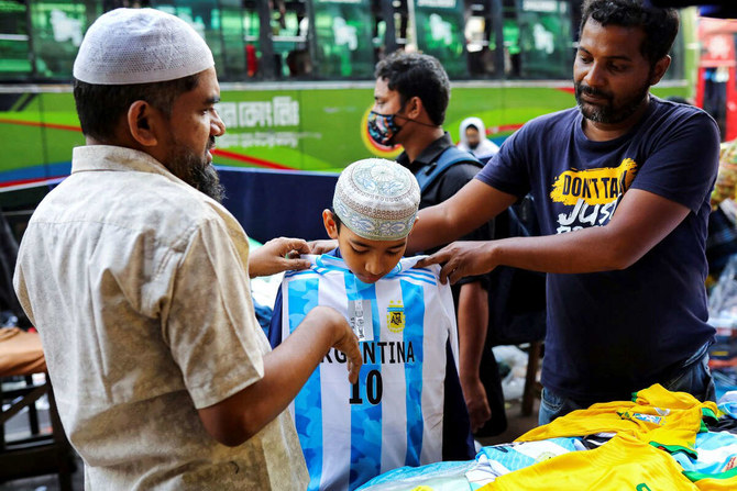 A young fan of Argentina tries a jersey from a street shop ahead of the FIFA World Cup, in Dhaka, Bangladesh, Nov. 16, 2022.  