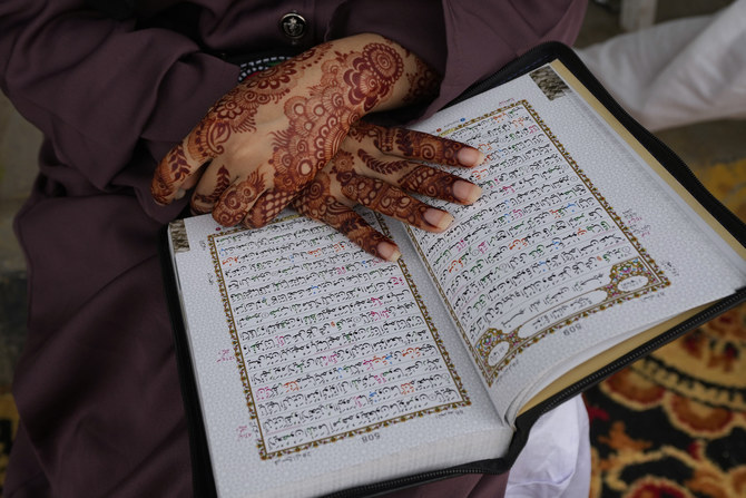 A Muslim woman recites from the Qur’an during a demonstration to denounce the burning of a Qur’an that took place in Sweden.