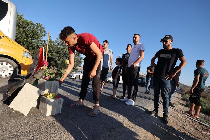 Mourners lay roses at the site where three Palestinians where killed by Israeli forces near the Jenin camp. (AFP)