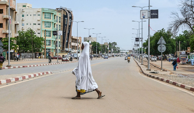 A woman walks across a road in Niamey on August 8, 2023. (AFP)