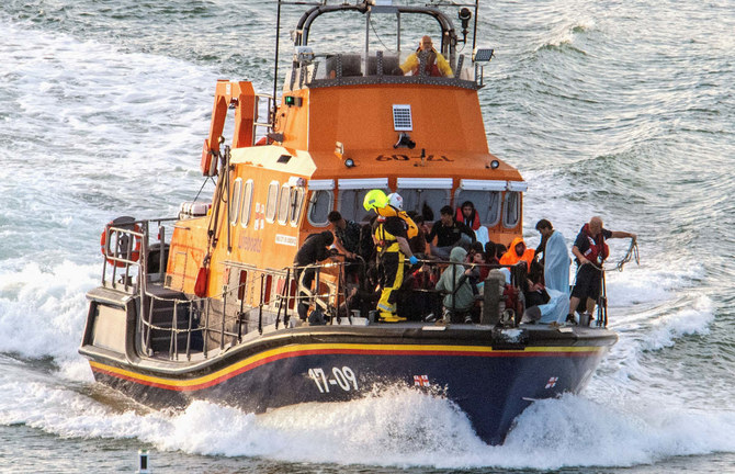 Rescue personnel bring migrants ashore on Saturday. (Reuters)