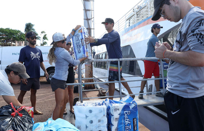 Volunteers load donated items onto a boat to be transported to Lahaina on August 12, 2023 in Wailuku, Hawaii. (AFP)