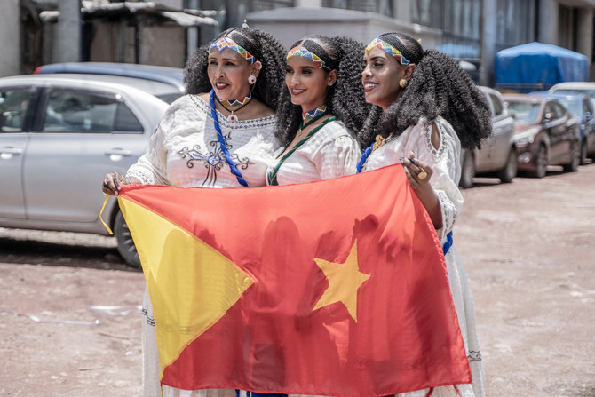 Women pose for a photograph while holding a Tigrayan flag during Ashenda festival in Addis Ababa, Ethiopia, on August 24, 2023. 