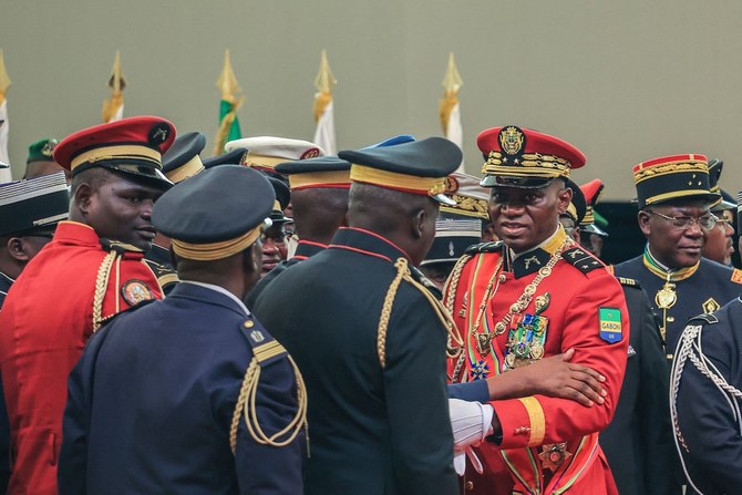 Gabon’s new strongman General Brice Oligui Nguema (2nd R) greets members of staff after he was inaugurated as interim president.