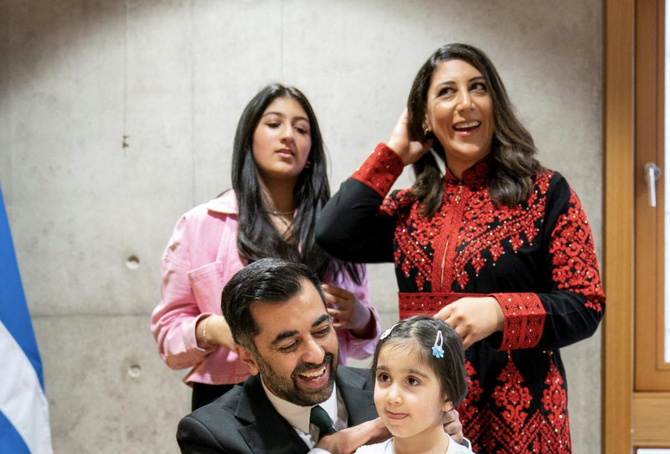 Humza Yousaf (C) is surrounded by his wife Nadia El-Nakla (rear R), his daughter Amal (2nd R), and his step-daughter Maya.