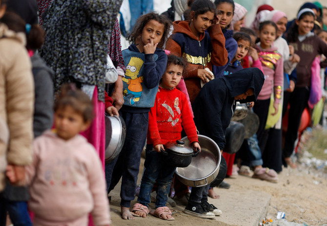 Palestinians stand in a line as they wait to receive food amid shortages of food supplies in Rafah in the southern Gaza Strip.