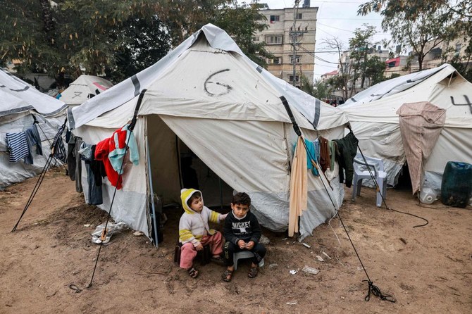 Children sit at the entrance of a tent at a make-shift camp for displaced Palestinians in Rafah in the southern Gaza Strip.