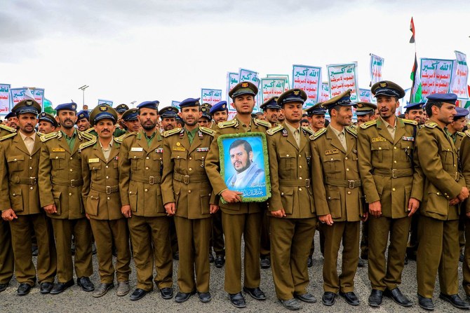 Members of Houthi-affiliated security forces hold a portrait of the militia’s leader Abdul Malik Al-Houthi.