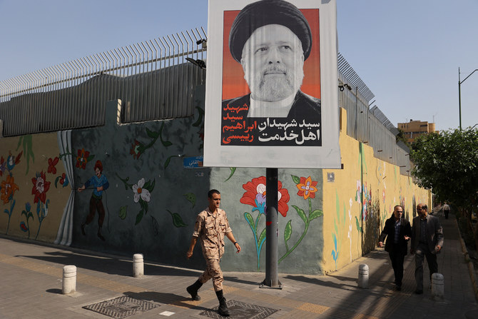 A person walks past a banner with a picture of the late Iran’s President Ebrahim Raisi on a street in Tehran, Iran May 20, 2024.