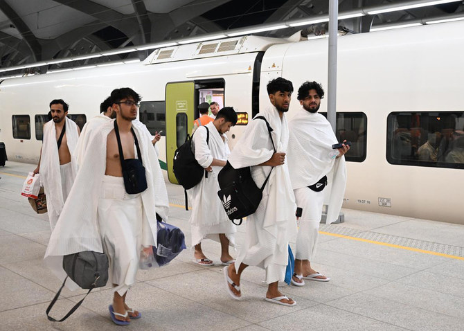 Umrah pilgrims wearing ihram walk at a Haramain High Speed Railway station. (SPA)