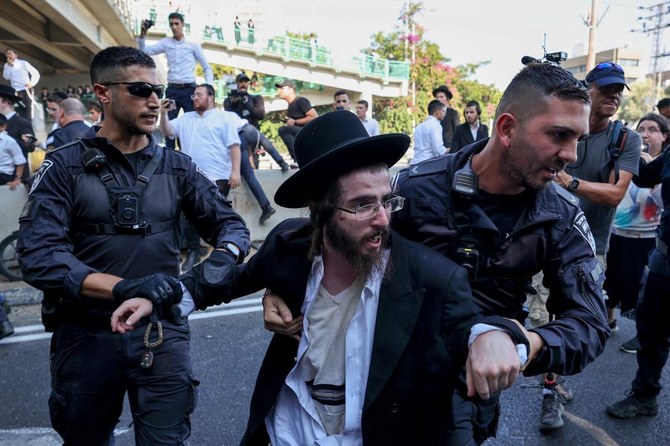 Police detain an ultra-Orthodox Jewish man during a protest against a ruling by a top Israeli court.