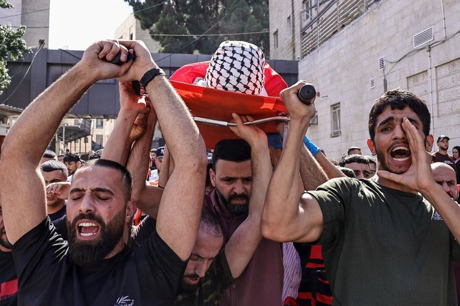 Mourners carry the body of Ghassan Ghareeb, who was killed during an Israeli raid in the occupied West Bank, during his funeral 