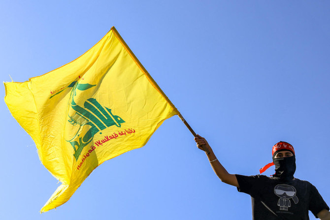 A masked demonstrator waves a Hezbollah flag during a demonstration supporting the Palestinians in Beirut. (File/AFP)