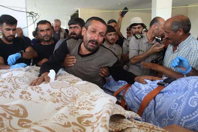 Relatives and friends mourn over the bodies of three children killed in Israeli strikes during their funeral in Al-Qasmiya area.