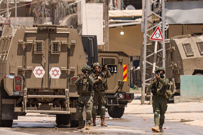 Israeli army soldiers take position during a raid in the Nur Shams camp for Palestinian refugees in the occupied West Bank. 