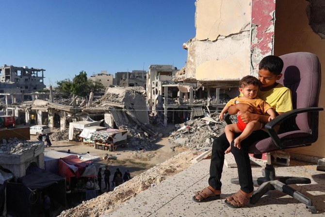 Palestinian children sit on the balcony of their house which was heavily damaged by Israeli bombardment.