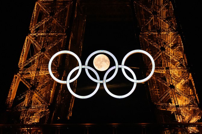 The moon rises behind the Olympic rings displayed on the Eiffel Tower in Paris ahead of the Paris 2024 Olympic Games. AFP