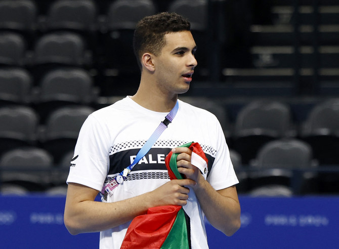 Yazan Al Bawwab of Palestine, with a Palestine flag before training. REUTERS