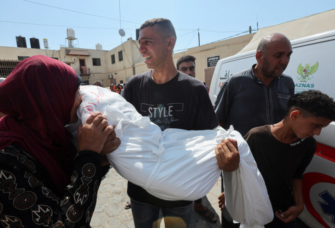 Palestinians mourn a relative killed in an Israeli strike at Al-Aqsa Martyrs Hospital in Deir Al-Balah in the central Gaza Strip