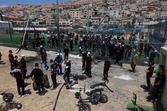 Members of the Druze community look at the damaged fence at a football pitch on July 28, 2024 in the Druze town of Majdal Shams 