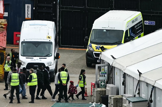 Migrants picked up at sea attempting to cross the English Channel from France are escorted ashore at the marina in Dover.