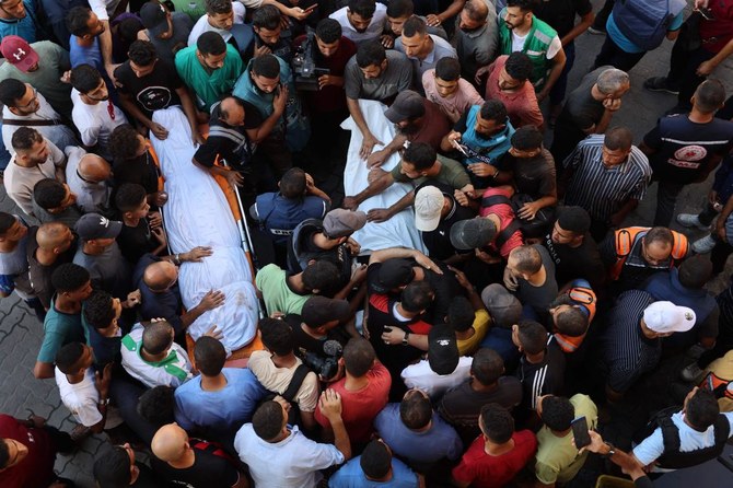 Mourners surround bodies of Al Jazeera Arabic journalist Ismail Al-Ghoul and cameraman Rami Al-Refee, killed in Israeli strike.