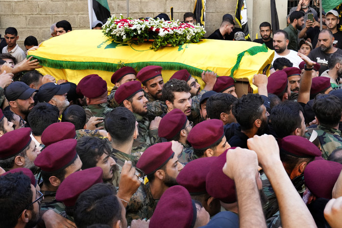 Hezbollah fighters carry the coffin of their top commander Fuad Shuku during his funeral procession in Beirut. 