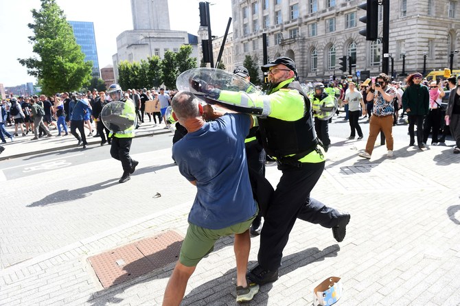 Police officers try to restrain a protester in Liverpool on August 3, 2024 during the “Enough is Enough” demonstration.