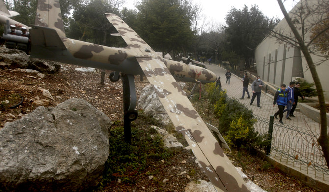 People pass by a replica drone in a war museum operated by Hezbollah in Mlita village, southern Lebanon, on Feb. 19, 2022. (AP)