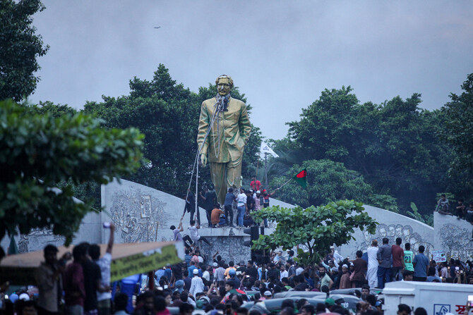 Anti-government protesters try to topple a statue of Sheikh Mujibur Rahman, Bangladesh’s founding father, in Dhaka on August 5.