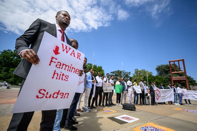 A man holds a placard during a demonstration on the opening day of Sudan ceasefire talks, in Geneva, on August 14, 2024. (AFP)