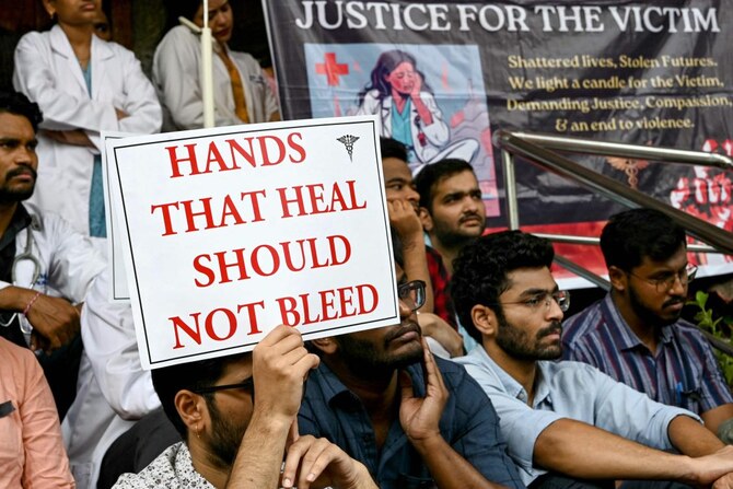 Doctors hold posters as they strike to protest the rape and murder of a young medic from Kolkata, at the Gandhi Hospital.