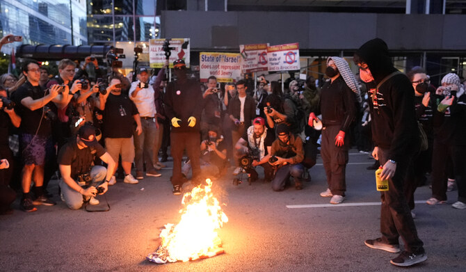 Protesters burn a flag near the Israeli Consulate during the Democratic National Convention Tuesday, Aug. 20, 2024, in Chicago. 