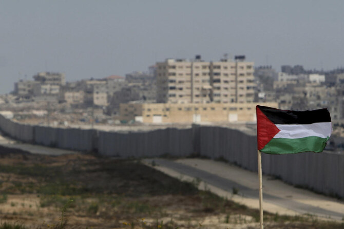 A Palestinian flag is seen with the background of a section of the wall in the Philadelphi corridor between Egypt and Gaza