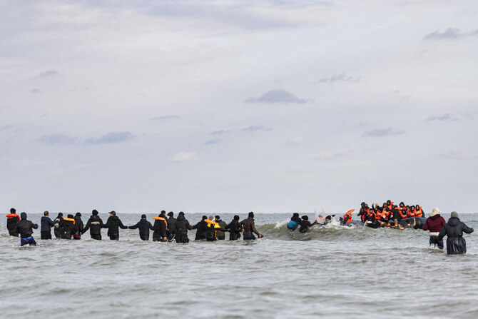 Migrants board a smuggler’s boat in an attempt to cross the English Channel, on the beach of Gravelines, near Dunkirk.