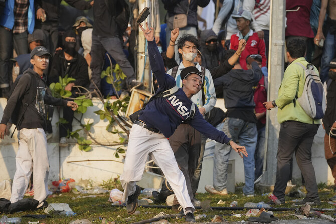 A protester throws a rock toward riot police during a rally against controversial changes to election laws.