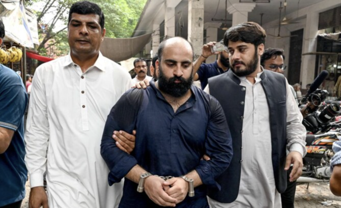 FIA personnel escort Farhan Asif (C), arrested allegedly over cyber terrorism, to a court in Lahore.