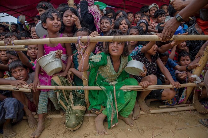 Rohingya children refugees wait, squashed against each other, to receive food handouts distributed to children and women.