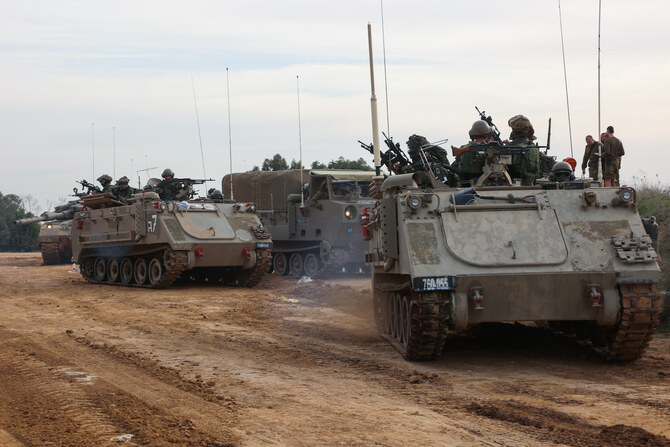 Israeli troops prepare weapons and military vehicles by the border fence before entering the Gaza Strip. (File/AFP)