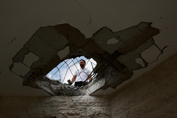 An official property surveyor assesses the damage to a residential building following a direct-hit from a projectile.