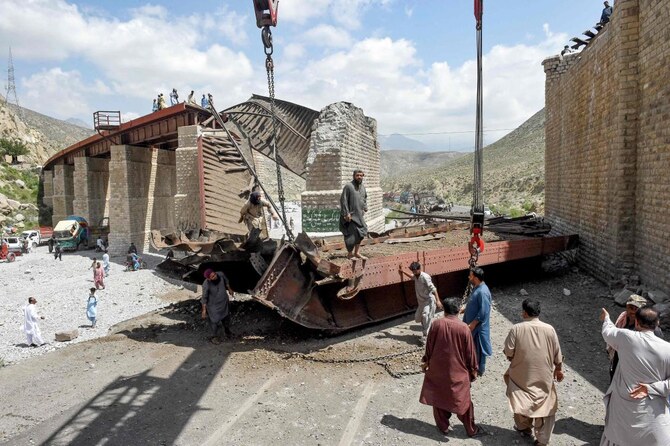 Railway workers clear the wreckage of a collapsed railway bridge the morning after a blast by separatist militants at Kolpur.