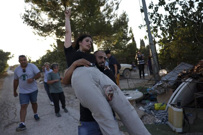 An injured activist bitten by a settler’s dog is evacuated as activists confront settlers in Al-Makhrour in occupied West Bank