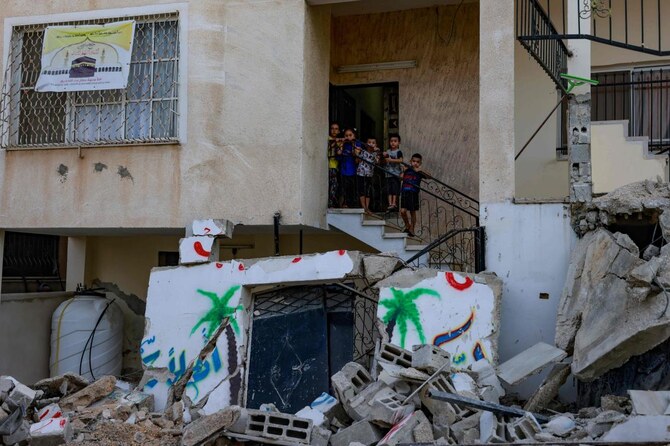 Palestinian children stand amid the destruction caused by an Israeli raid in the Nur Shams camp near Tulkarem