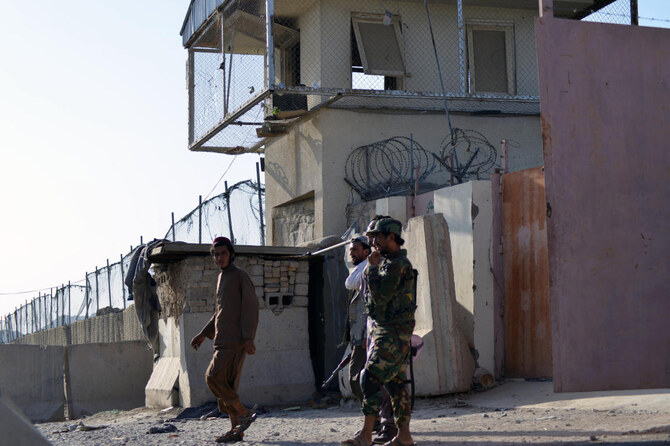 Taliban members stand guard at an entrance of the Panjwai district police headquarters in Kandahar province. (File/AFP)