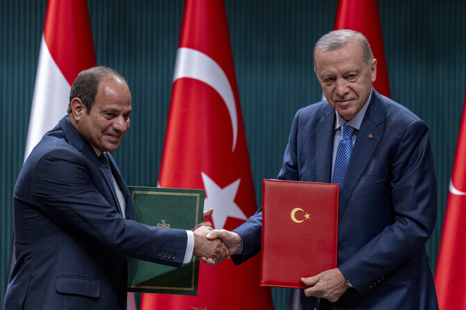 Turkish President Recep Tayyip Erdogan shakes hands with Egyptian President Abdel Fattah El-Sissi.