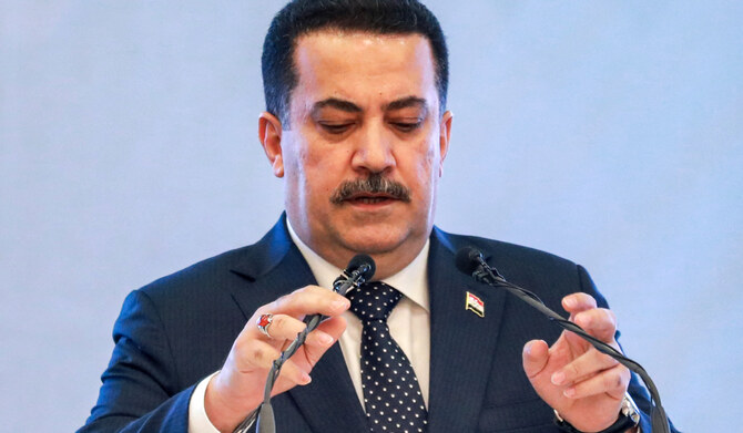 Iraq's Prime Minister Mohammed Shia al-Sudani adjusts his microphones before speaking during an event in Baghdad on May 3, 2024.